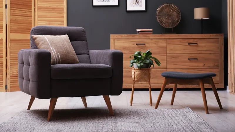Upholstered armchair beside a wooden sideboard